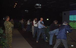 A group of civilians trying out one of the ADFs Weapon Training Simulation Systems.